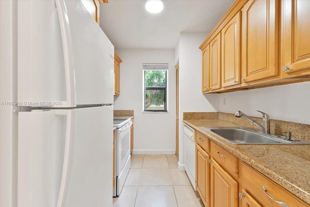 kitchen with light tile patterned floors, white appliances, light stone counters, and sink