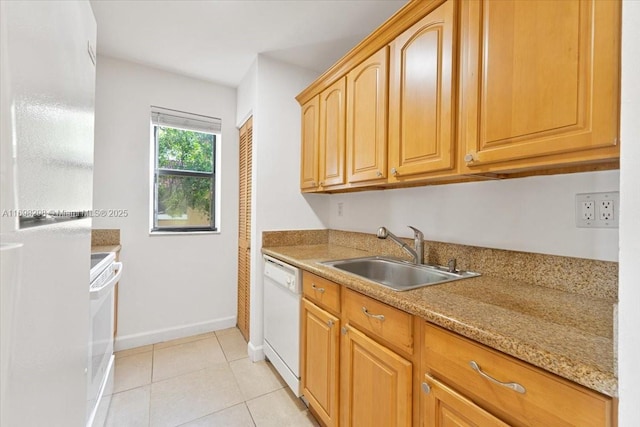 kitchen with light stone countertops, sink, light tile patterned floors, dishwasher, and range