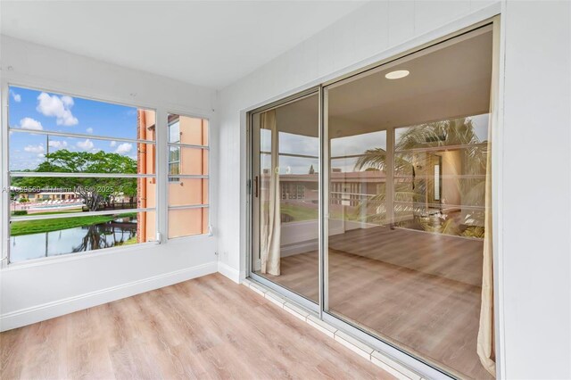 unfurnished sunroom featuring a water view