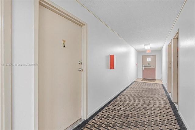 hall with a textured ceiling