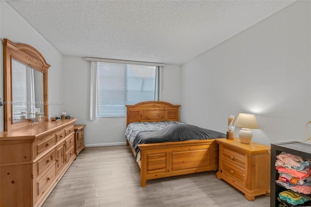 bedroom featuring light wood-type flooring and a textured ceiling