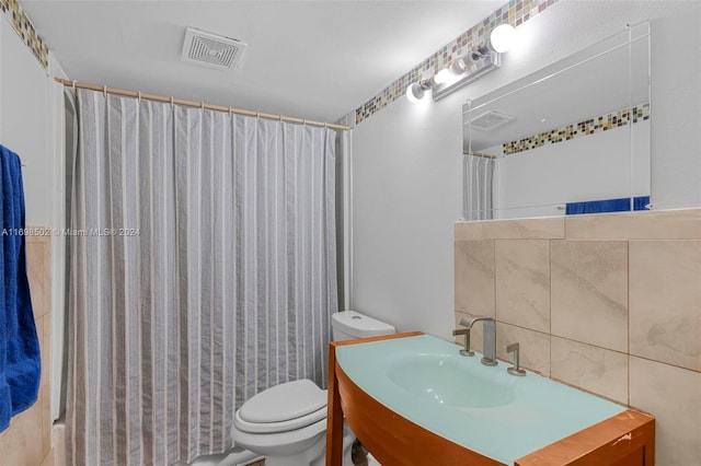 bathroom with sink, walk in shower, backsplash, toilet, and tile walls