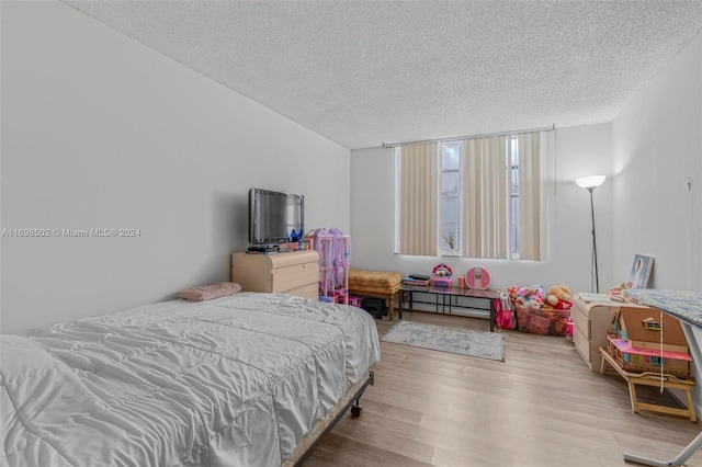 bedroom with light hardwood / wood-style floors and a textured ceiling