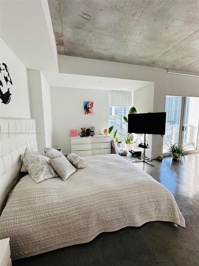 bedroom with concrete flooring and access to outside