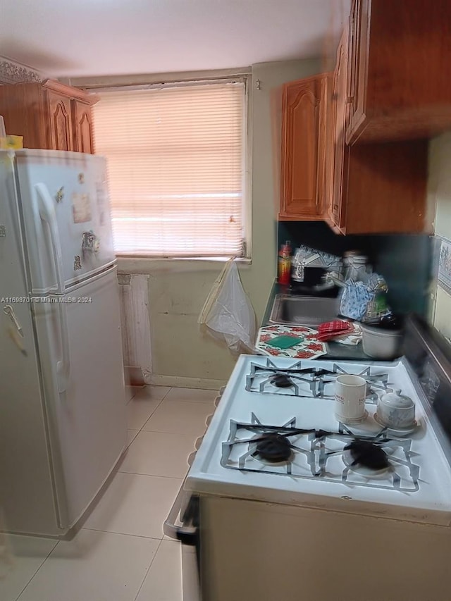 kitchen featuring light tile patterned flooring and white appliances