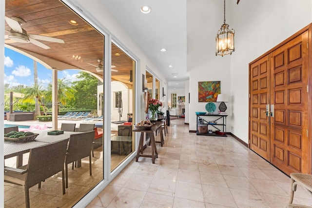 entryway featuring ceiling fan with notable chandelier and wooden ceiling