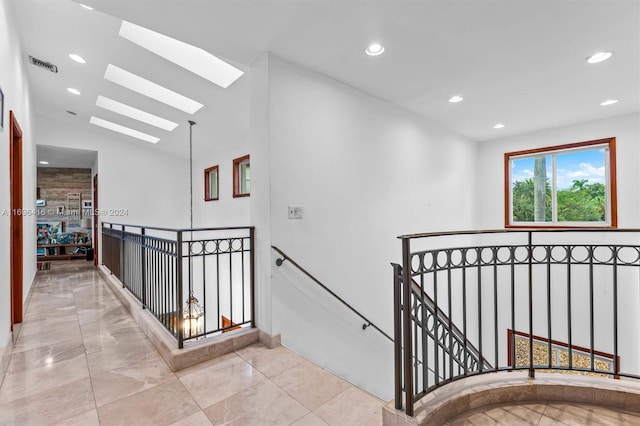 staircase featuring lofted ceiling with skylight