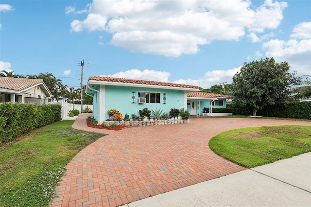 view of front of home with cooling unit and a front yard