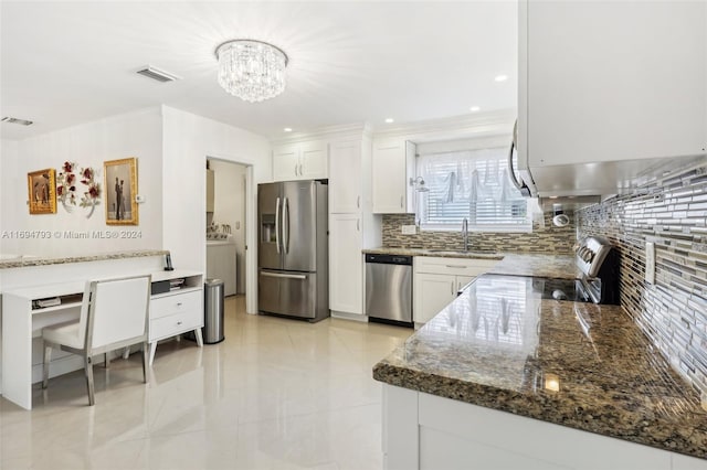 kitchen with sink, dark stone countertops, appliances with stainless steel finishes, tasteful backsplash, and white cabinetry