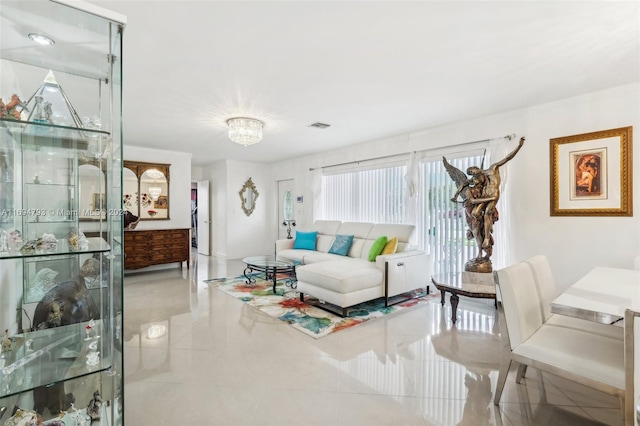 living room featuring light tile patterned floors and an inviting chandelier