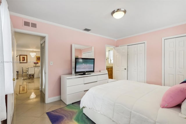 bedroom featuring crown molding, light tile patterned flooring, and two closets