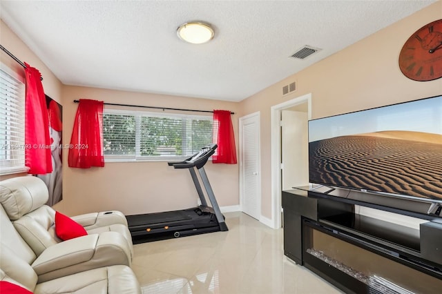 workout room featuring a textured ceiling