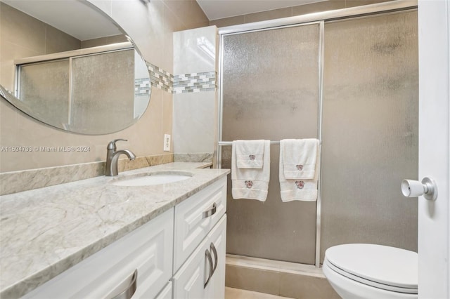 bathroom with tile patterned floors, vanity, toilet, and an enclosed shower