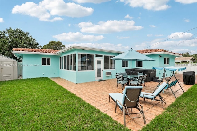 rear view of house featuring a patio, a storage shed, a sunroom, a yard, and a hot tub