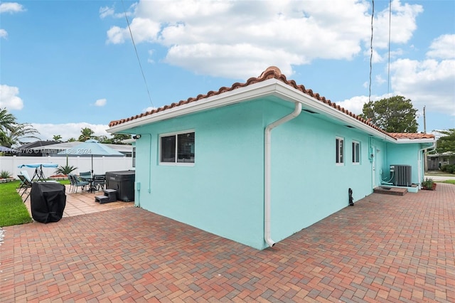 view of property exterior featuring a patio area and central AC