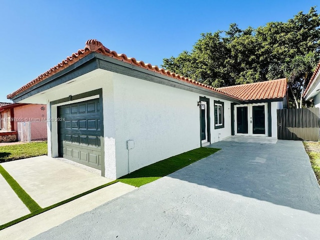 mediterranean / spanish-style home featuring a garage and french doors