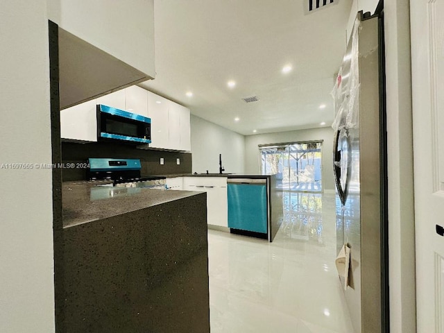 kitchen with white cabinets, kitchen peninsula, sink, and appliances with stainless steel finishes