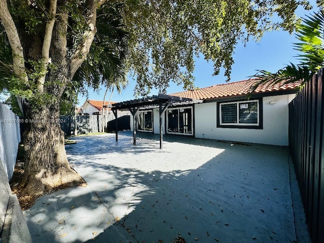 rear view of house featuring a pergola and a patio area