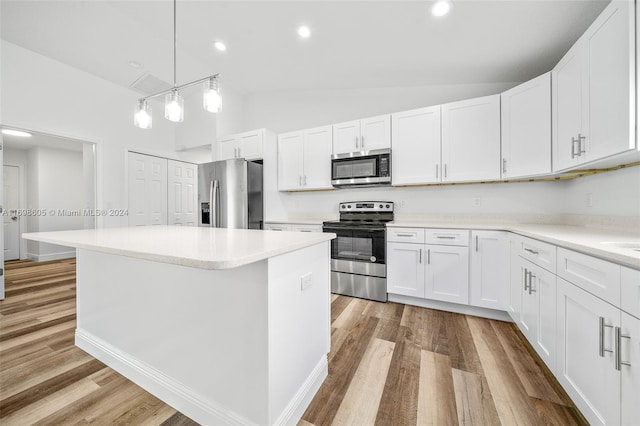 kitchen featuring stainless steel appliances, white cabinetry, light hardwood / wood-style flooring, a kitchen island, and lofted ceiling