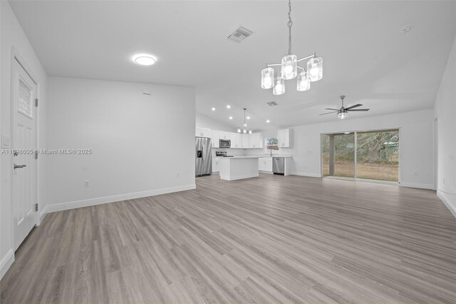 kitchen with white cabinets, decorative light fixtures, a kitchen island, dark hardwood / wood-style flooring, and stainless steel appliances