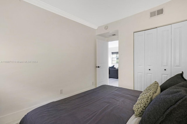 bedroom with a closet and ornamental molding