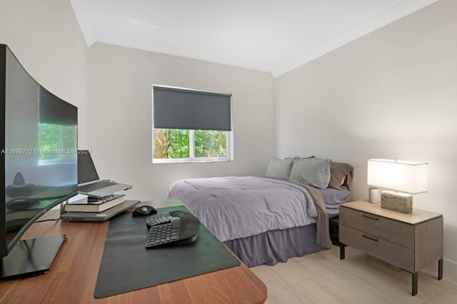 bedroom with ornamental molding and light tile patterned floors