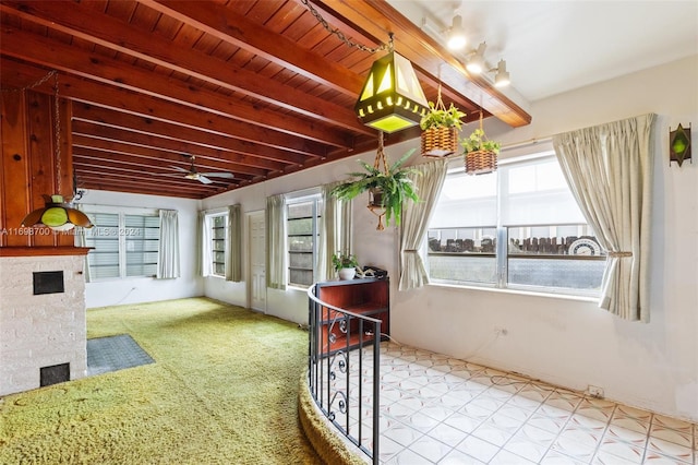 unfurnished sunroom featuring beamed ceiling and wood ceiling