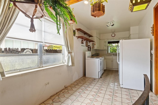 kitchen with white cabinetry, white appliances, and light tile patterned floors