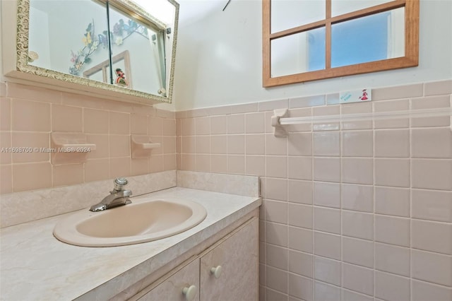 bathroom with vanity and tile walls