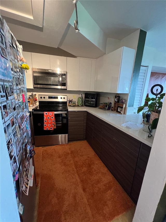 kitchen featuring dark brown cabinetry, white cabinetry, carpet floors, and appliances with stainless steel finishes