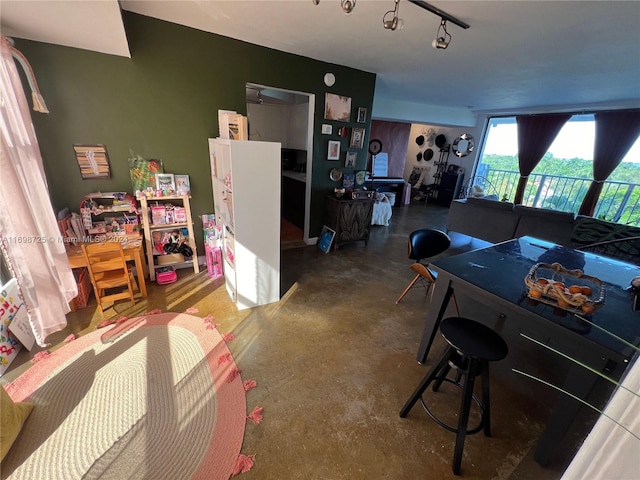 interior space with ceiling fan, concrete flooring, and track lighting