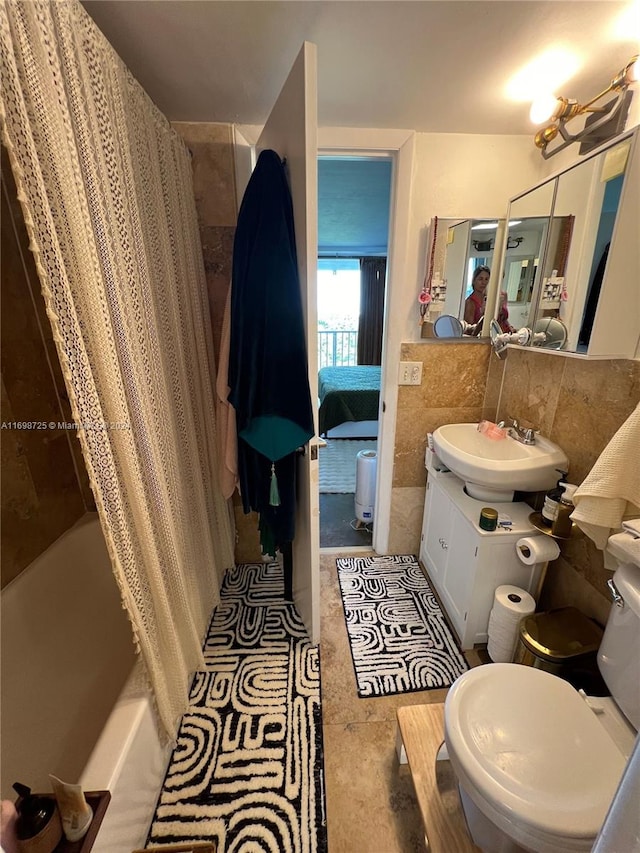 full bathroom featuring vanity, shower / bath combo, tile walls, and toilet