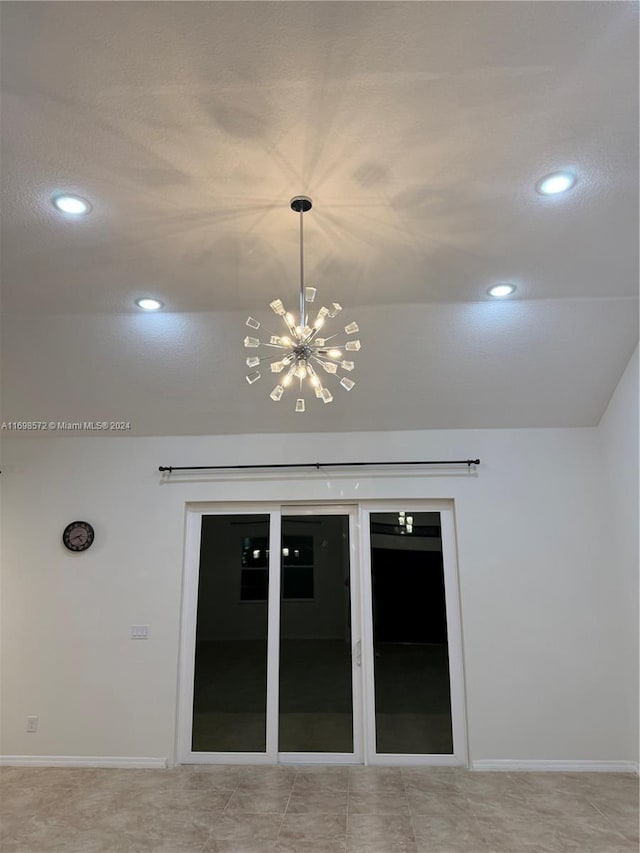 interior space featuring lofted ceiling and a chandelier