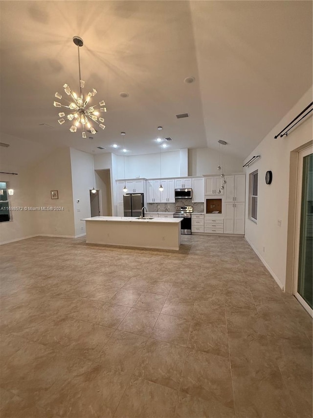 kitchen with stainless steel appliances, a kitchen island with sink, sink, decorative light fixtures, and white cabinets