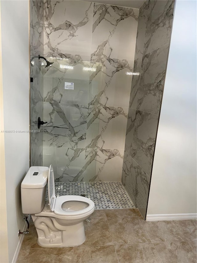 bathroom featuring toilet and a tile shower