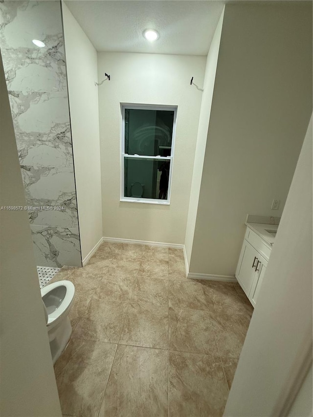 bathroom featuring vanity, a textured ceiling, toilet, and walk in shower