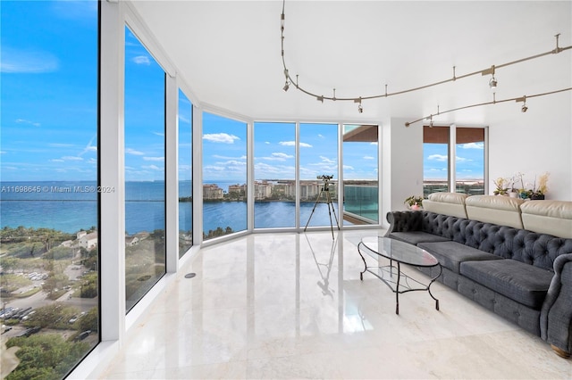 sunroom featuring a water view