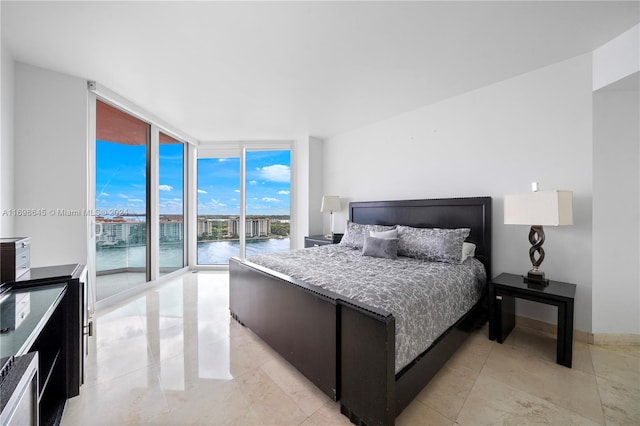 bedroom featuring access to exterior, a water view, and floor to ceiling windows