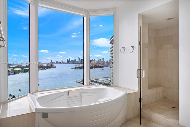 bathroom with tile patterned flooring, separate shower and tub, and a water view