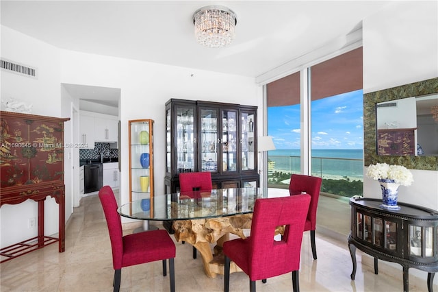 dining area with a water view and a notable chandelier