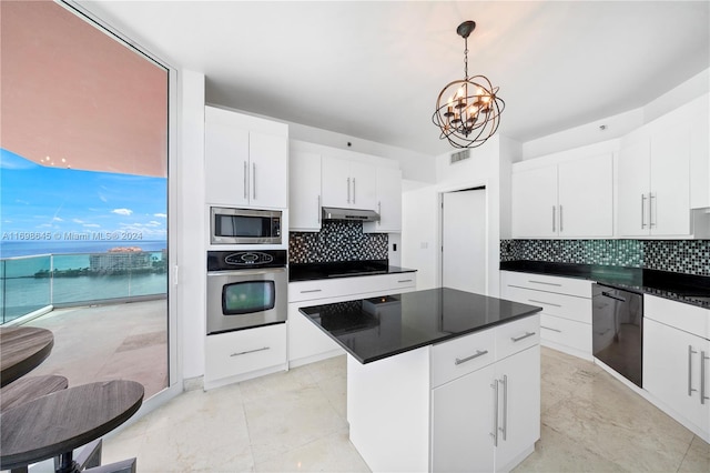 kitchen with a center island, black appliances, a water view, tasteful backsplash, and white cabinetry