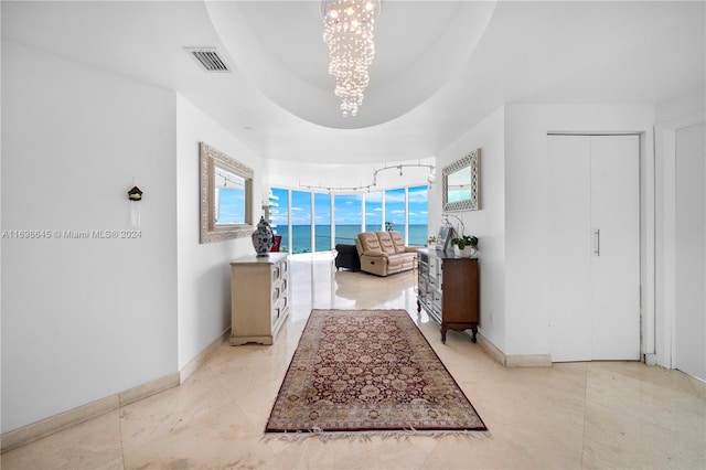 bathroom featuring a wealth of natural light, tile patterned flooring, a water view, and a chandelier