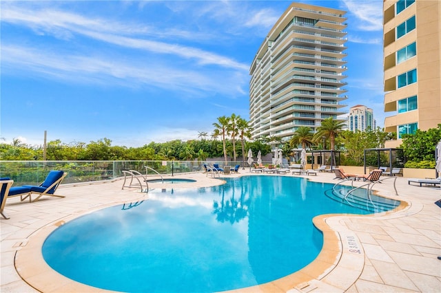 view of pool featuring a community hot tub and a patio