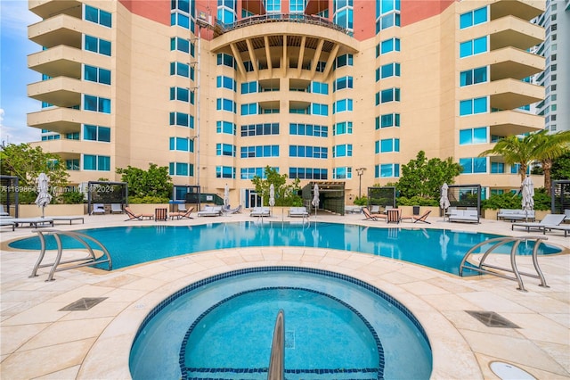 view of swimming pool featuring a community hot tub and a patio