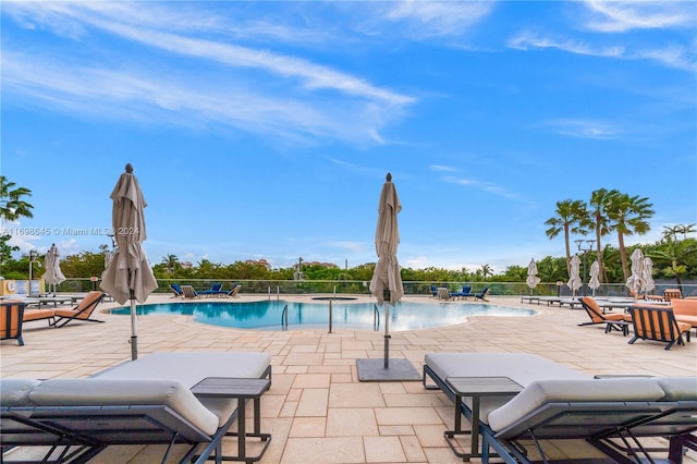 view of swimming pool with a patio area and a hot tub