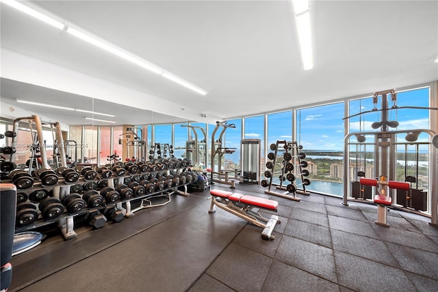 exercise room with a water view and expansive windows