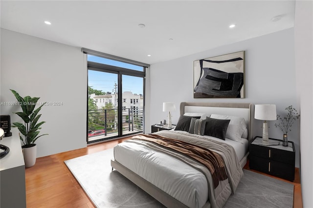 bedroom with access to exterior and wood-type flooring