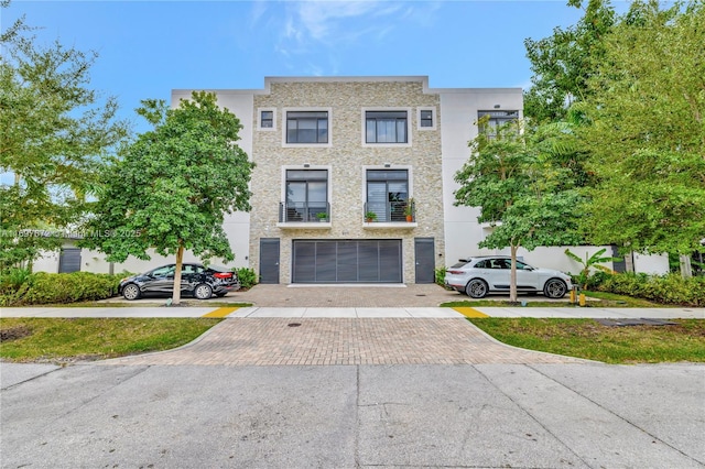 909 NE 16th Ter Unit 2, Fort Lauderdale, FL 33304 - view of front facade with an attached garage, driveway, and stucco siding