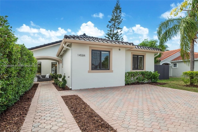 14584 SW 115th St, Miami, FL 33186 - view of front of home with stucco siding, a tile roof, a patio, and an outdoor hangout area