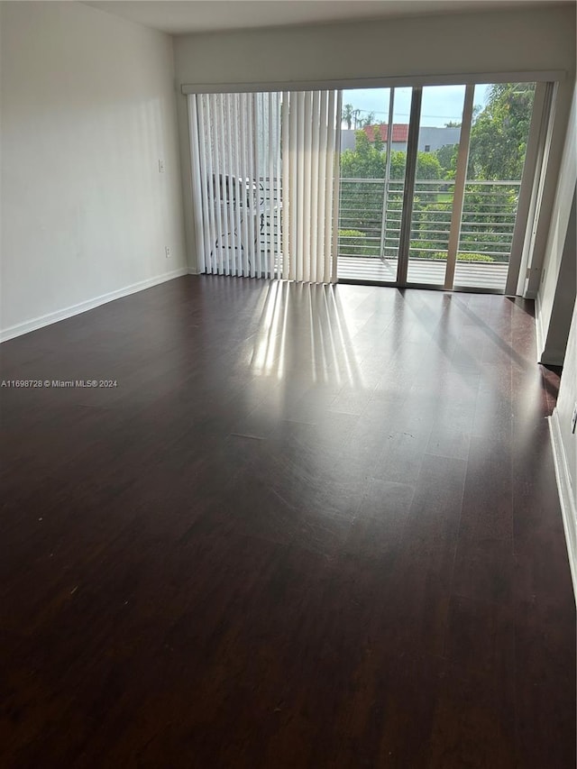 unfurnished room with dark wood-type flooring